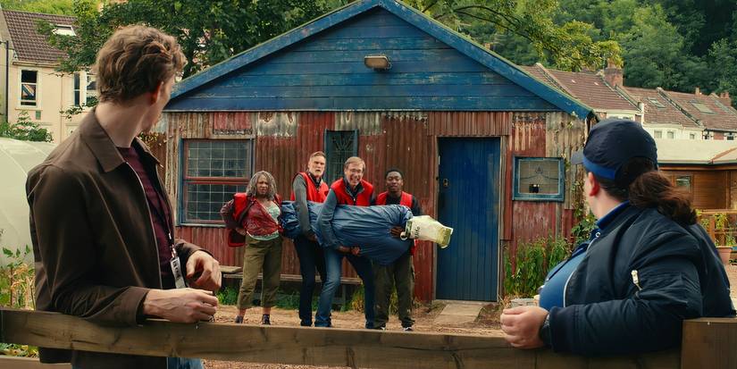 Myrna (Clare Perkins), John (Darren Boyd), Greg (Stephen Merchant), and Christian/Ben (Gamba Cole) get caught smuggling a dead body in 'The Outlaws' (2021).