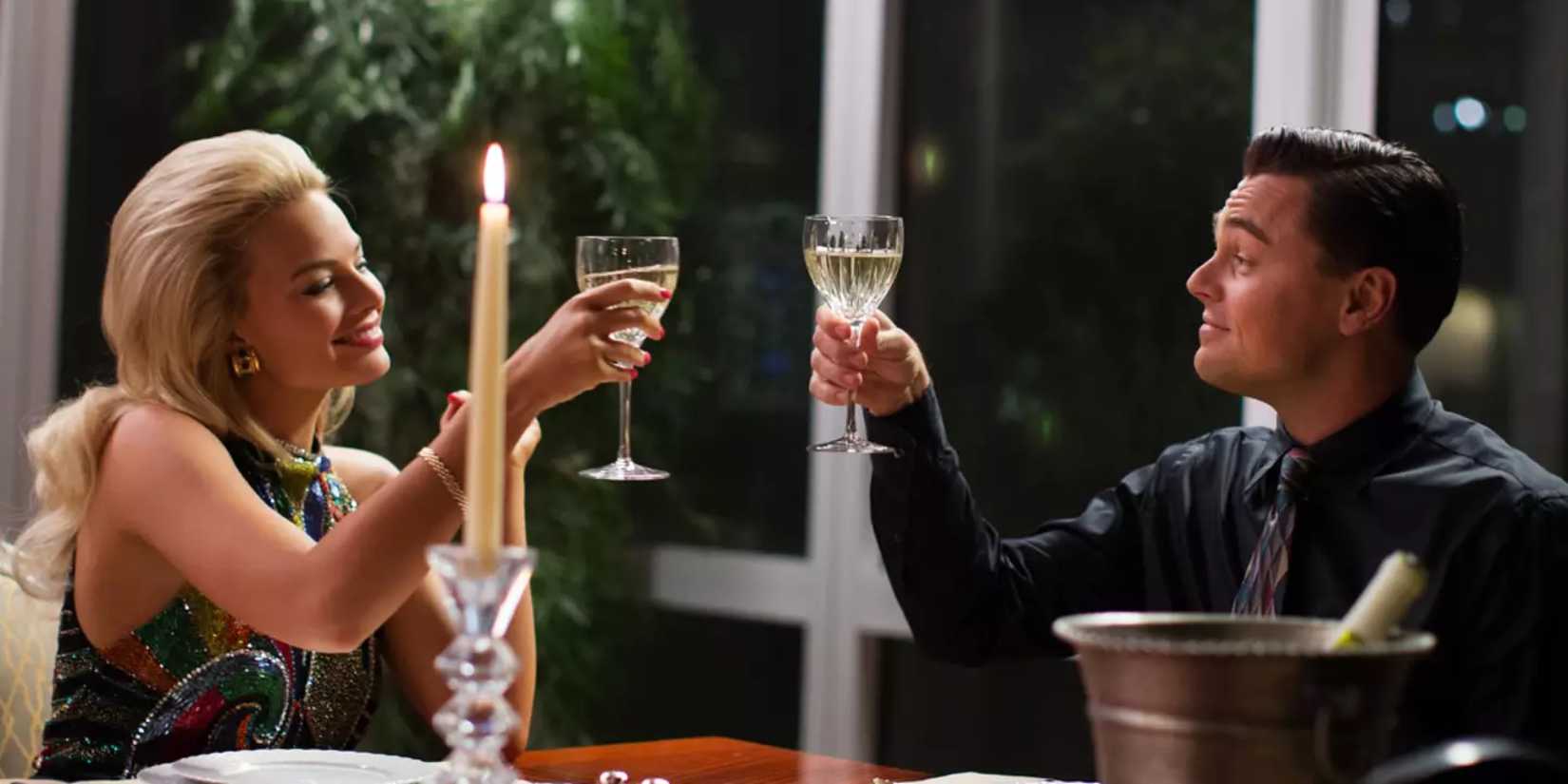 Naomi and Jordan toasting at dinner in The Wolf of Wall Street