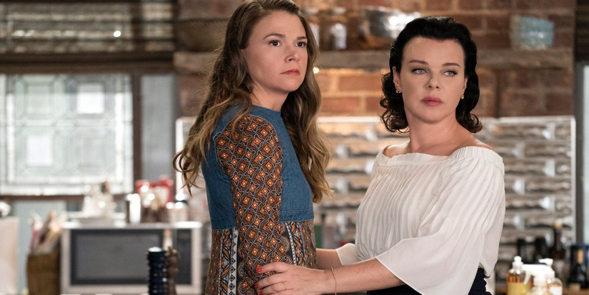 Liza (Sutton Foster) and her roommate Maggie (Debbie Mazar) look serious near a kitchen in Younger.
