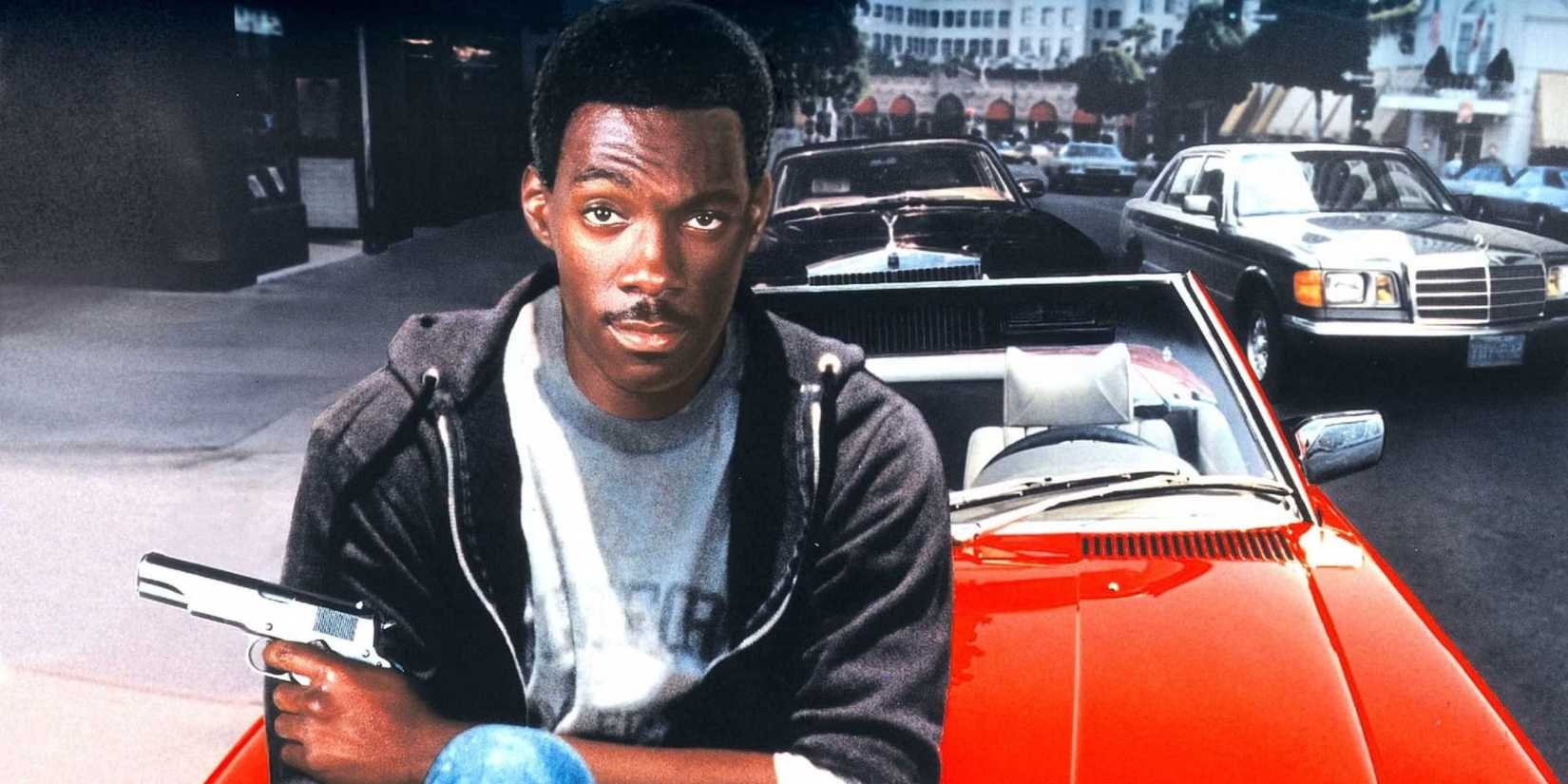Eddie Murphy posing on a car with a gun on the poster for Beverly Hills Cop, 1984.