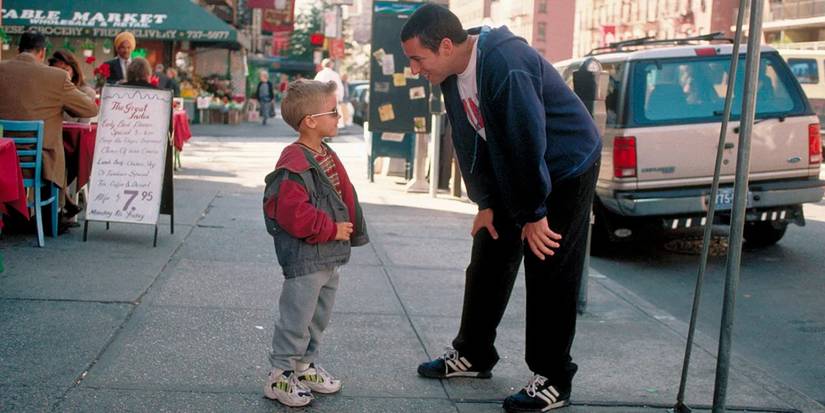 Cole Sprouse as Dylan and Adam Sandler as Sonny talk on the streets of New York in a scene from 'Big Daddy.'