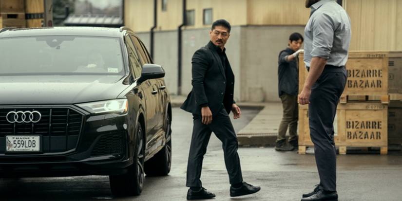Brian Tee, walking out of the car in a black suit, as Francis Xavier Quinn in Reacher Season 3.