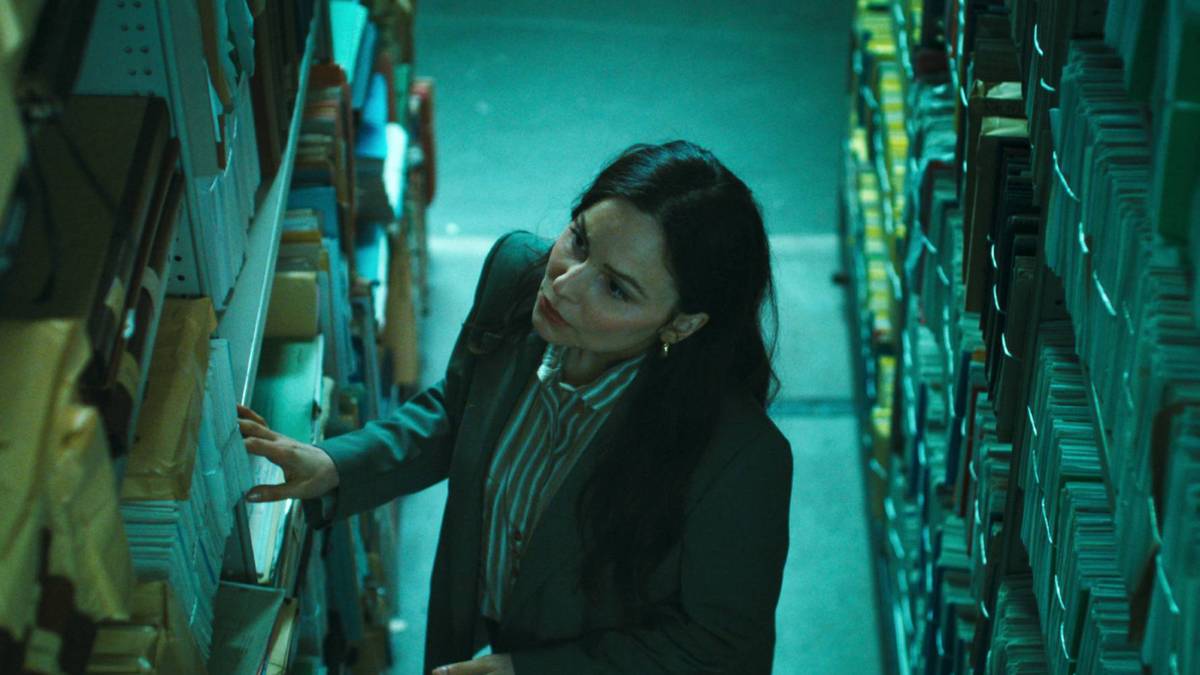 Mina Tander as Samira looking through city archives in Netflix's Cassandra.