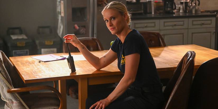 Leven Rambin as Audrey sitting at a table with a walkie-talkie