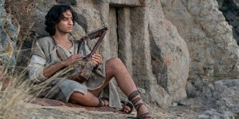 David (Michael Iskander) sits with his lyre beside the rocks on 'House of David'.
