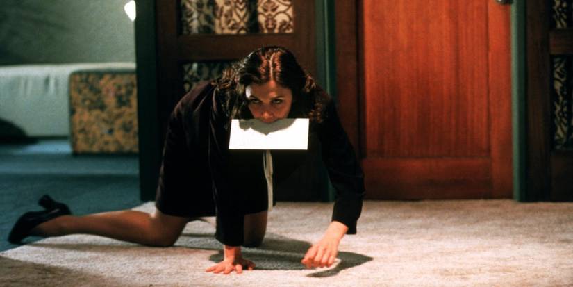Maggie Gyllenhaal as Lee Holloway, crawling across an office floor with paper in her mouth in Secretary