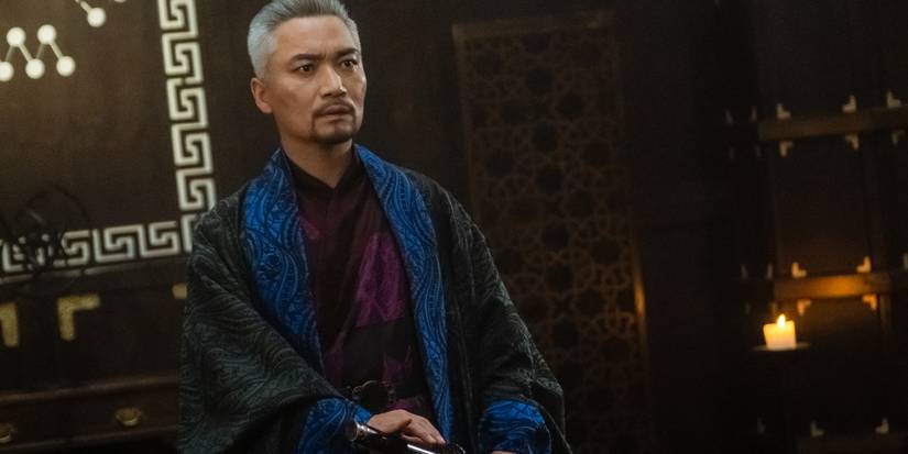 Jo Jae-yoon as Jin Mu with gray hair and a goatee in lavish colorful clothes holds a sword in Alchemy of Souls.