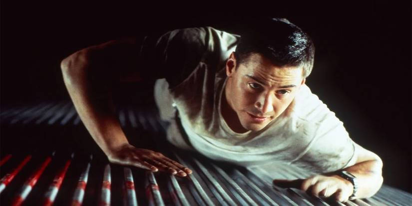 Keanu Reeves as Jack crawling through a vent in Speed