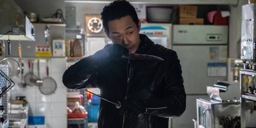Park Sung-woong holding two knives and heading towards someone off-screen in Bloodhounds.