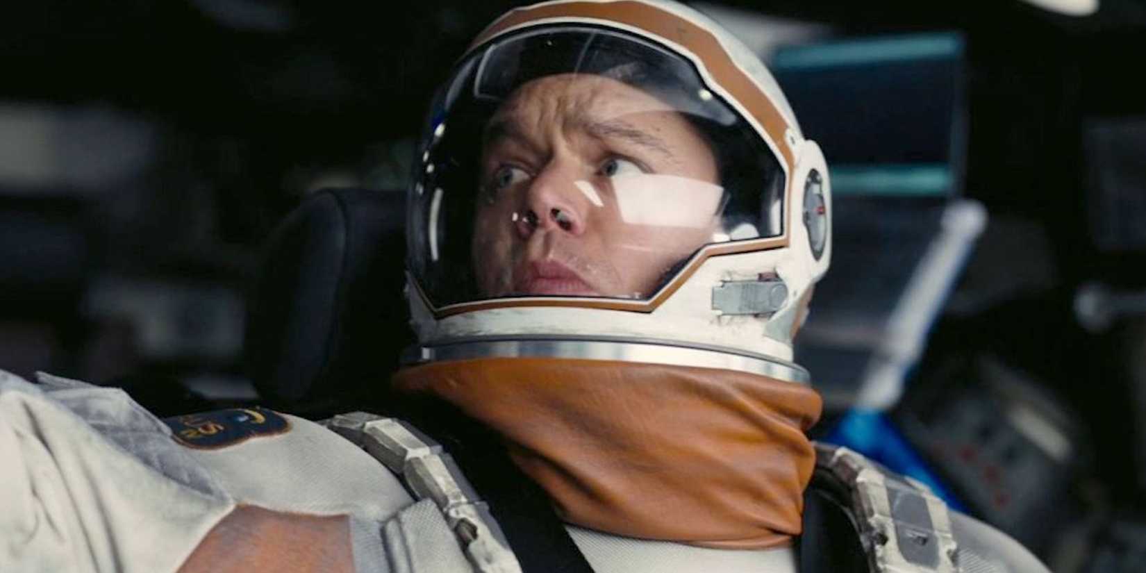 Matt Damon as Hugh Mann fiddles with equipment in his spacesuit in Interstellar (2014)