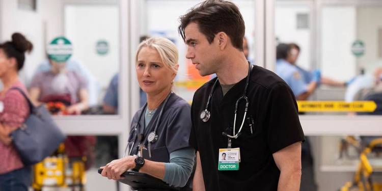 Nurse Evans and Dr. Langdon stand in scrubs in the ER in 'The Pitt'.