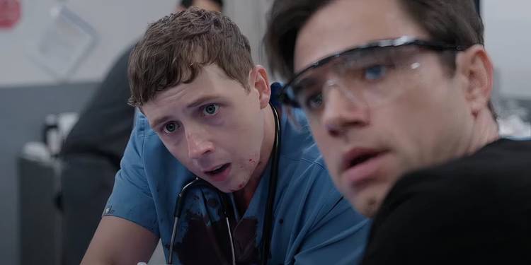 Dr. Whitaker with blood-covered scrubs stands next to Dr. Langdon in 'The Pitt'