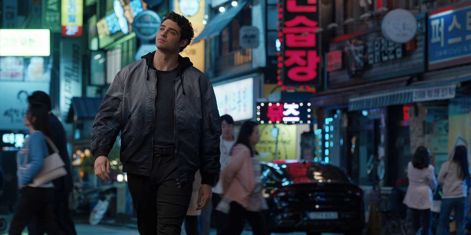 Noah Centineo as Owen Hendricks walking down a busy South Korean street in season 2 of The Recruit 
