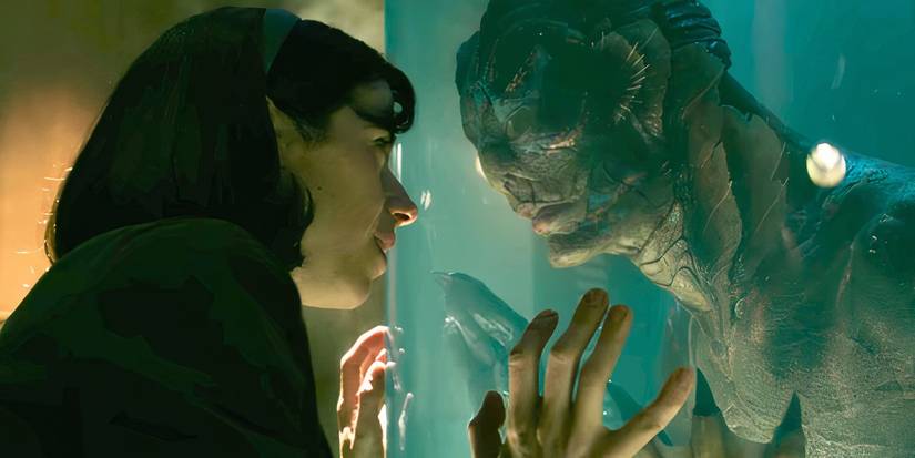 Sally Hawkins as Elisa and Doug Jones as The Amphibian Man lock eyes through a tank in The Shape of Water.