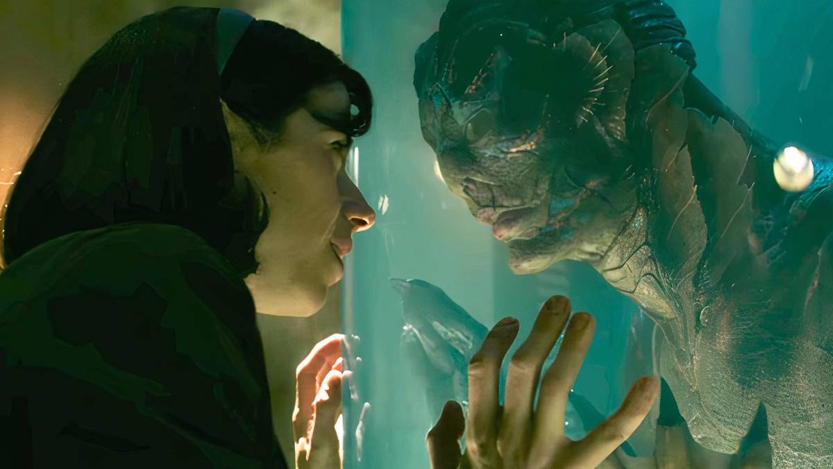 Sally Hawkins as Elisa and Doug Jones as The Amphibian Man lock eyes through a tank in The Shape of Water.