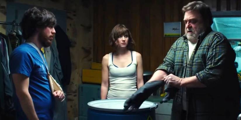 John Goodman, Mary Elizabeth Winstead, and John Gallagher Jr. around a barrel in 10 Cloverfield Lane.