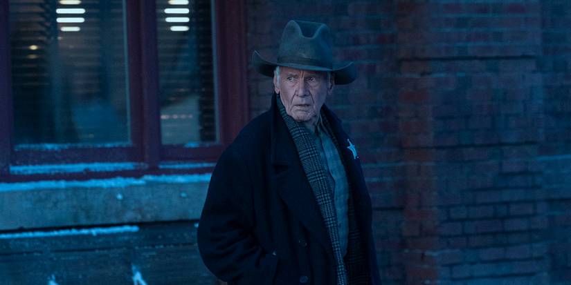 Harrison Ford as Jacob Dutton in a coat and hat outside a building in winter in 1923 Season 2, Episode 6.