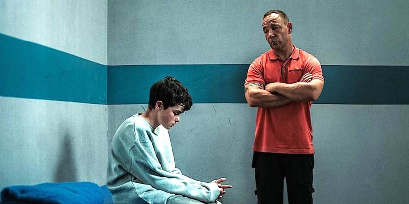 Owen Cooper como Jamie Miller fica em uma sala segura com Stephen Graham como Eddie Miller nas proximidades na adolescência.