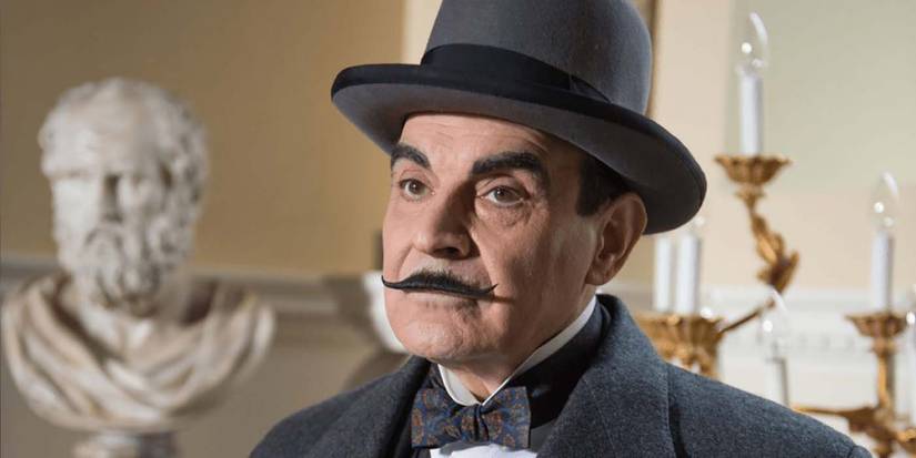 Poirot with a top hat and long moustache looking serious in Agatha Christie's Poirot.