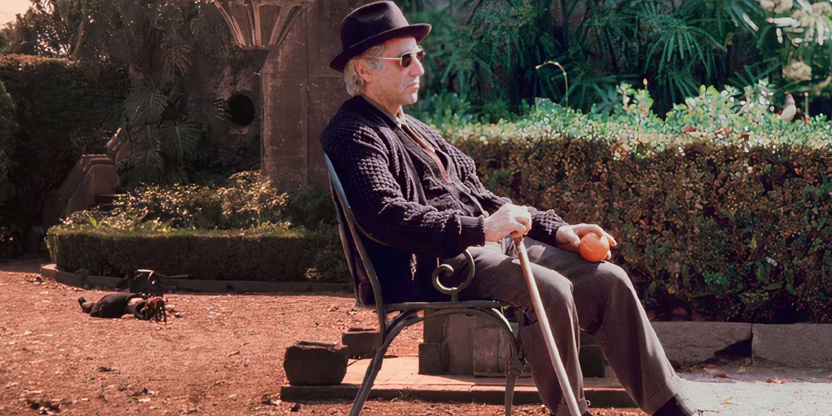 Al Pacino as Michael Corleone sitting in a chair outside alone in The Godfather Part III (1990)