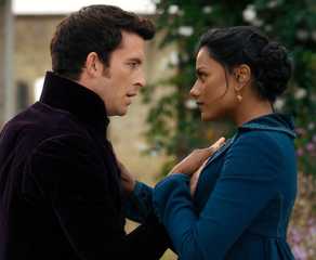 A man and woman stare intimately at each other as they stand outside and hold hands in Bridgerton.