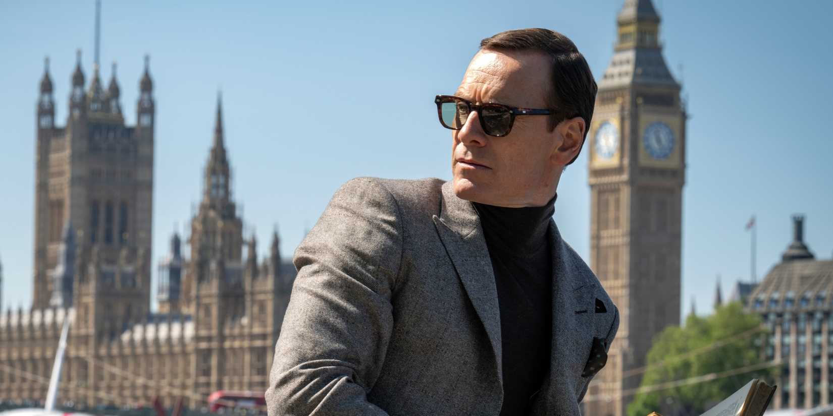 Michael Fassbender as George Woodhouse outside in sunglasses looking over his right shoulder in Black Bag