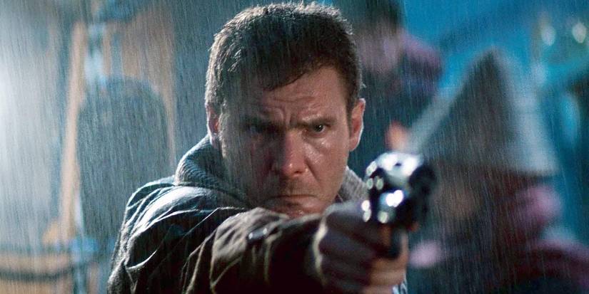Harrison Ford as Rick Deckard pointing a gun in the rain in Blade Runner.