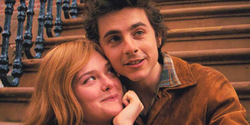Timothee Chalamet and Elle Fanning sit on front steps outside an apartment and smile in A Complete Unknown.