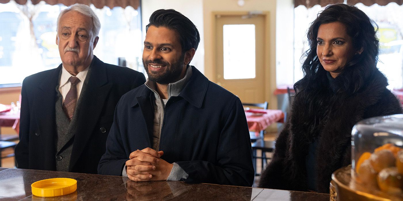 Three people stand at a restaurant counter and smile in Deli Boys.
