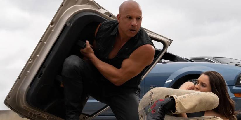 Vin Diesel as Dominic Toretto using a car door as a shield in Fast X.