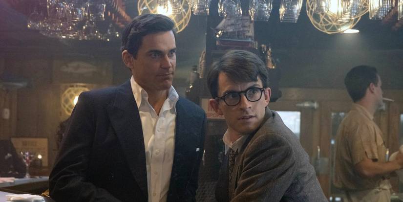 Matt Bomer and Jonathan Bailey as Hawk and Tim, sitting at a bar in 'Fellow Travelers'