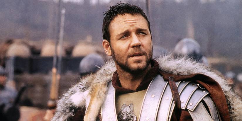 Russell Crowe como Maximus em Gladiador usando armadura e uma capa de pele entre seu exército.