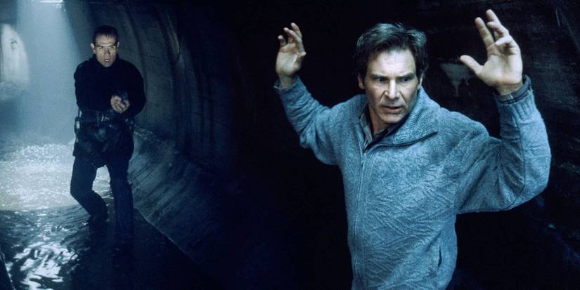 Harrison Ford raising his hands while Tommy Lee Jones approaches him in The Fugitive