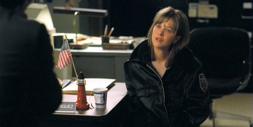 Meg Ryan as Frannie wearing a police jacket and sitting at a police station in In the Cut 