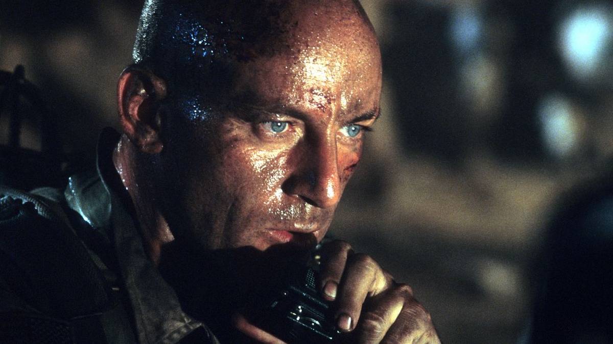 Jason Isaacs talking into a walkie-talkie in Black Hawk Down.