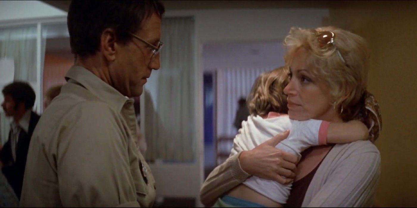 Martin Brody (Roy Scheider) talking to Ellen Brody (Lorraine Gray) holding her son in a hospital in 'Jaws'