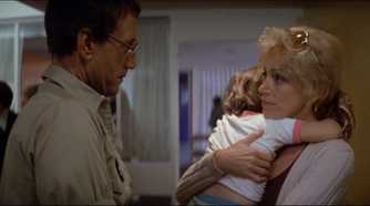 Martin Brody (Roy Scheider) talking to Ellen Brody (Lorraine Gray) holding her son in a hospital in 'Jaws'