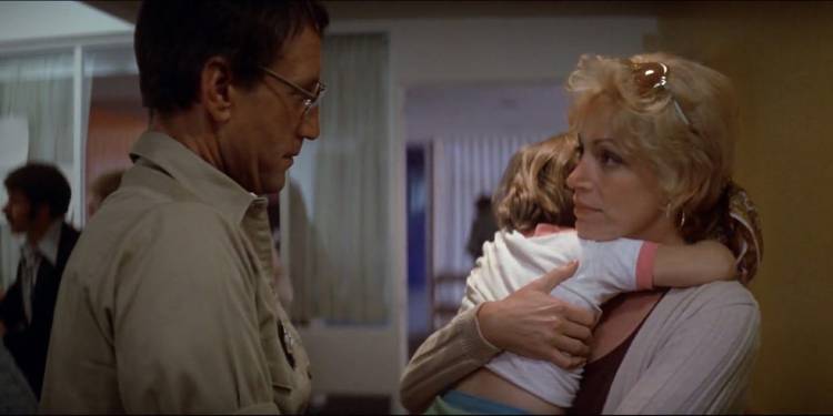 Martin Brody (Roy Scheider) talking to Ellen Brody (Lorraine Gray) holding her son in a hospital in 'Jaws'