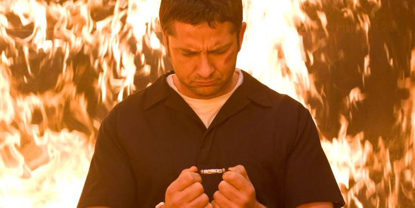 Gerard Butler's Clyde standing in front of flames in Law Abiding Citizen