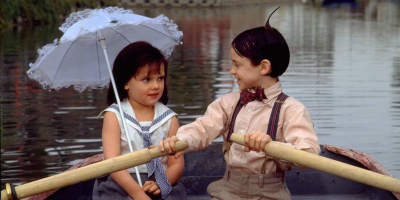 Bug Hall as Alfalfa rowing a boat with Brittany Ashton Holmes as Darla looking on in The Little Rascals.