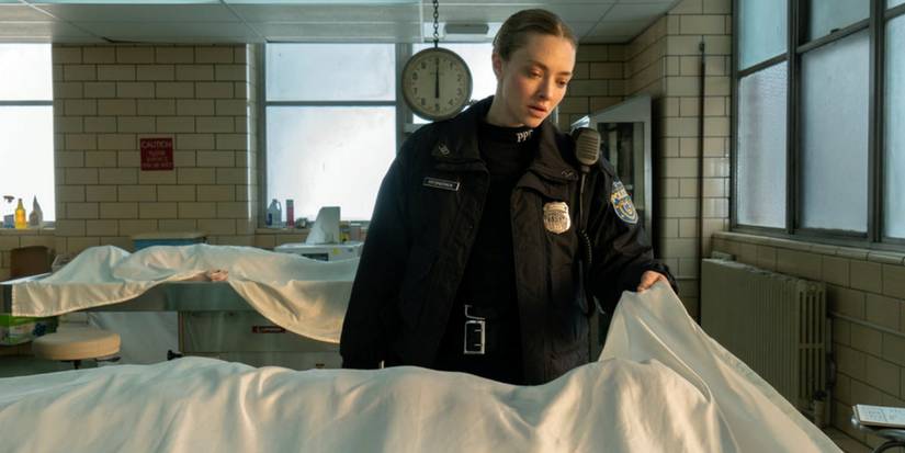 Amanda Seyfried as Mickey lifting up a sheet over a body in the morgue in Long Bright River.