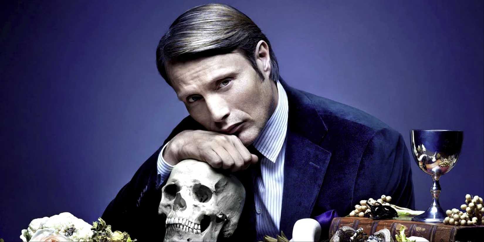 Mads Mikkelsen as Hannibal Lecter resting his chin on a human skull and looking at the camera in Hannibal