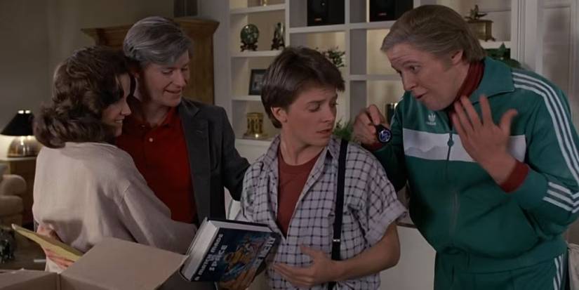 The McFlys (Lea Thompson and Crispin) Glover hugging, Marty (Michael J. Fox), and Biff (Thomas F. Wilson) at the end of 'Back to the Future'