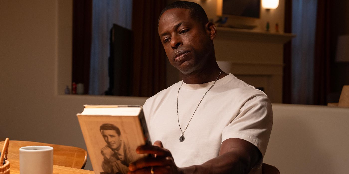 Sterling K. Brown looking at a hardback book in the Paradise finale.