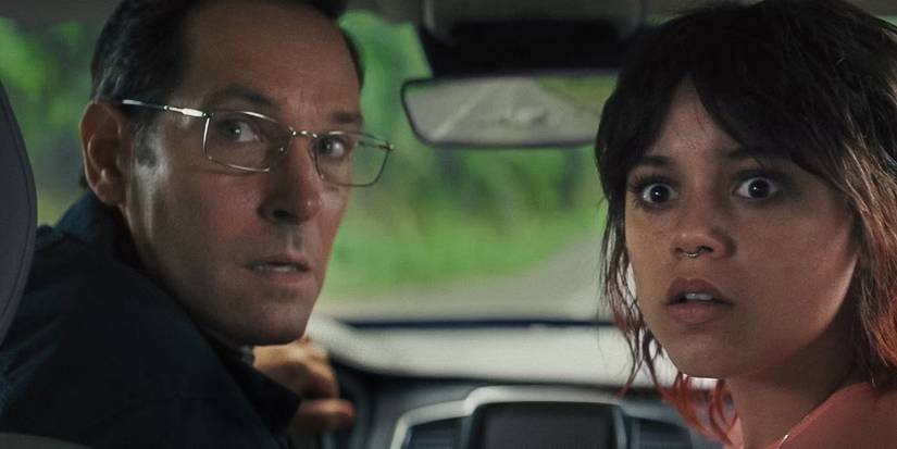 Paul Rudd as Elliot Kintner and Jenna Ortega as Ridley Kintner looking out the back car window in concern in Death of a Unicorn