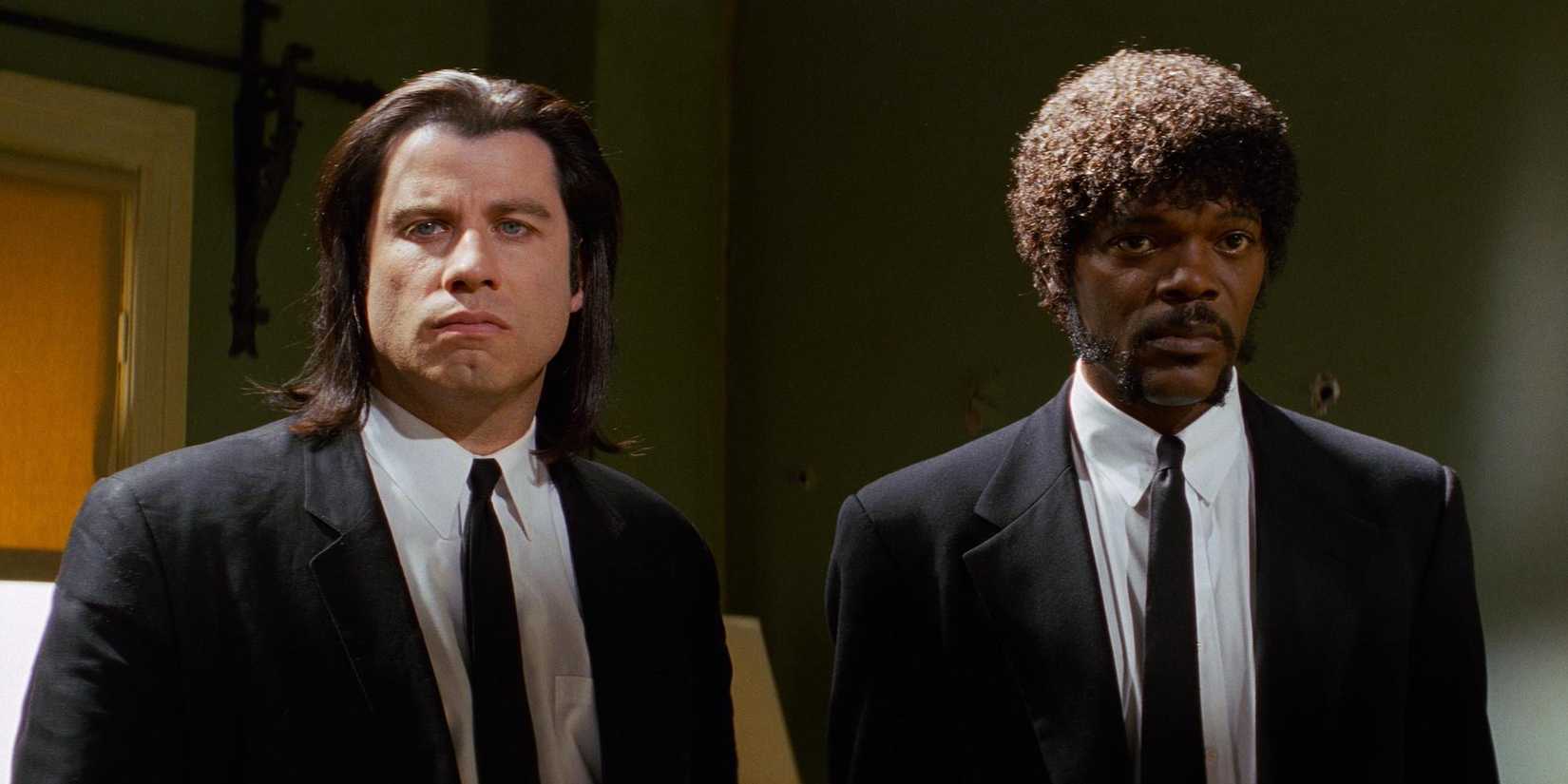 John Travolta as Vincent Vega and Samuel L. Jackson as Jules Winnfield staring ahead side by side in 'Pulp Fiction.'