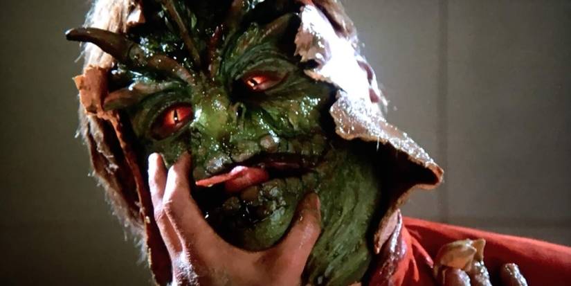A reptilian alien is exposed after having its mask torn off in 1983's V.