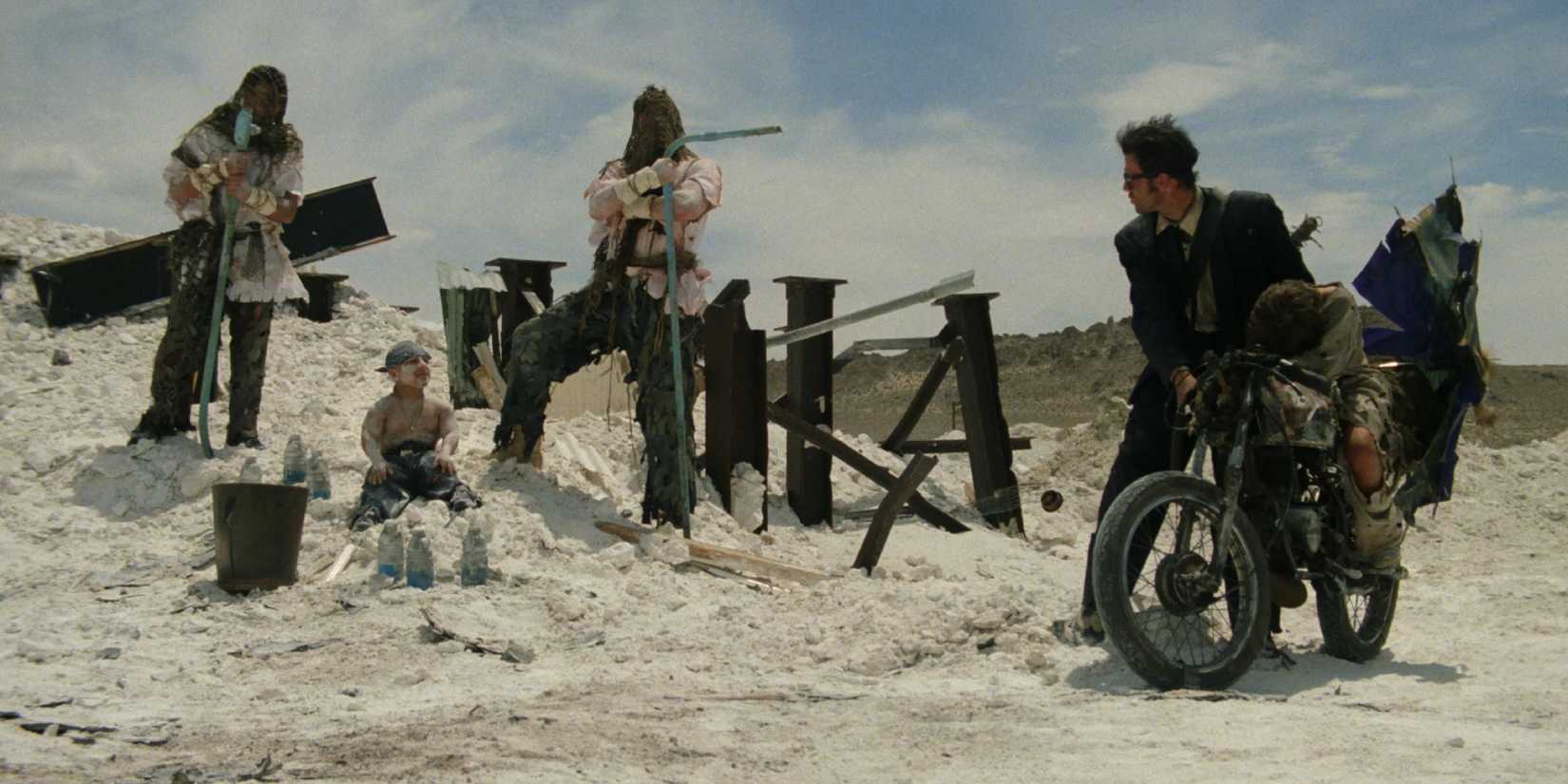 Dois homens apontando armas para outro homem em Six-String Samurai