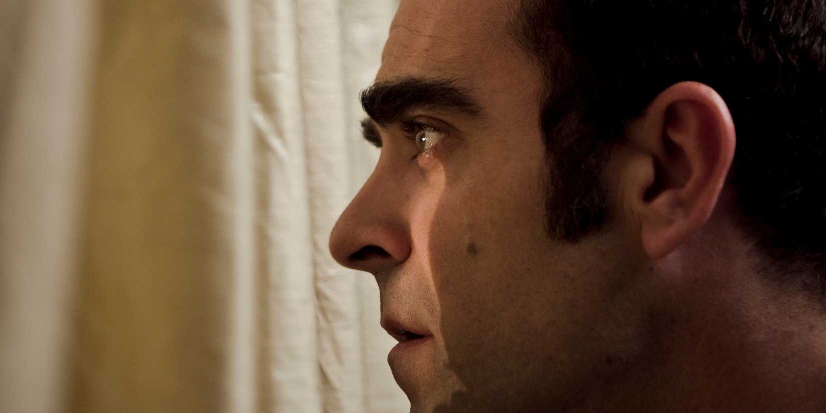 A man looking through a curtain in Sleep Tight