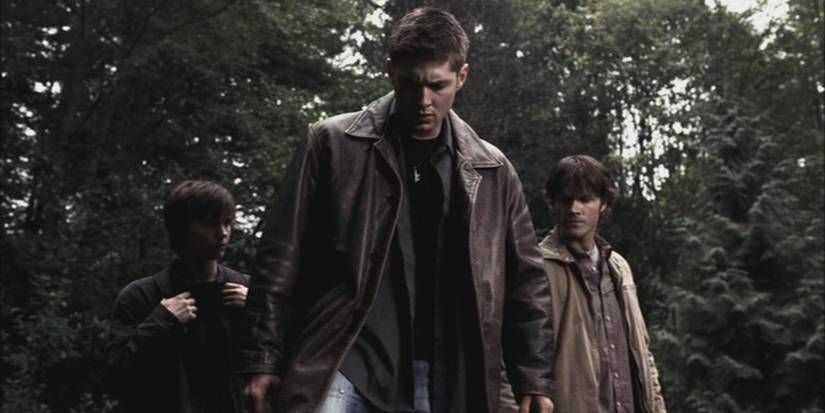 Dean Winchester (Jensen Ackles) dan Sam Winchester (Jared Padalecki) memimpin seorang anak laki-laki melewati hutan di 'Supernatural'